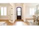 Bright entryway featuring hardwood floors, white trim, and an arched, dark-stained front door at 2415 Christenbury Hall Nw Dr, Concord, NC 28027