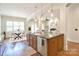 Open-concept kitchen island with pendant lighting, stainless steel appliances, and hardwood floors at 2415 Christenbury Hall Nw Dr, Concord, NC 28027