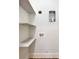 Functional laundry area with open shelving, utility connections, and neutral wall color at 2415 Christenbury Hall Nw Dr, Concord, NC 28027