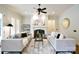 Cozy living room featuring a fireplace, ceiling fan, neutral walls, and natural light at 2415 Christenbury Hall Nw Dr, Concord, NC 28027