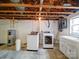 Unfinished basement laundry area features a washing machine, dryer, hot water heater, and utility sink at 24436 Nc 24/27 Hwy, Albemarle, NC 28001