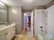 Bathroom featuring a shower and tub with a vanity and sink, complemented by gray walls and tile flooring at 24436 Nc 24/27 Hwy, Albemarle, NC 28001