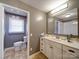 Neutral bathroom with large mirror, vanity with sink, and toilet, all illuminated by modern lighting at 24436 Nc 24/27 Hwy, Albemarle, NC 28001