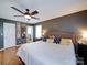 Well-lit bedroom featuring gray walls, hardwood floors, a window, and decor, all enhanced by a ceiling fan at 24436 Nc 24/27 Hwy, Albemarle, NC 28001