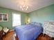 Bright bedroom featuring hardwood floors, green walls, a window, and elegant decor, all lit by a chandelier at 24436 Nc 24/27 Hwy, Albemarle, NC 28001