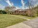 Beautifully landscaped brick home with a walkway leading to a welcoming red front door at 24436 Nc 24/27 Hwy, Albemarle, NC 28001