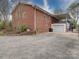 Rear view of the brick home featuring a patio and garage area at 24436 Nc 24/27 Hwy, Albemarle, NC 28001