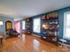 Hardwood floors gleam in this open living space, accented by shelves and a cozy reading nook by a bright red door at 24436 Nc 24/27 Hwy, Albemarle, NC 28001