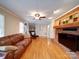 Inviting living space featuring a brick fireplace, hardwood floors, and comfortable seating arrangement at 24436 Nc 24/27 Hwy, Albemarle, NC 28001