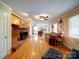 Expansive living room with a brick fireplace, hardwood floors, and seamless transition into the modern kitchen at 24436 Nc 24/27 Hwy, Albemarle, NC 28001
