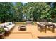 Outdoor deck featuring comfortable seating, a grill, and dining area surrounded by lush trees at 255 Honeysuckle Creek Loop, Mooresville, NC 28117