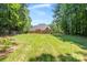 Expansive backyard with lush green grass, mature trees, and a view of the well-maintained home at 255 Honeysuckle Creek Loop, Mooresville, NC 28117