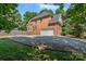 Side view of a brick home with an attached two-car garage and spacious driveway at 255 Honeysuckle Creek Loop, Mooresville, NC 28117