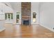 Open-concept living room with a stone fireplace and bright windows for natural lighting at 255 Honeysuckle Creek Loop, Mooresville, NC 28117