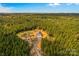 Expansive aerial view of a metal building surrounded by dense forest, with a gravel driveway and several parked vehicles at 2710 Wyatt Grove Church Rd, Richfield, NC 28137
