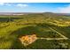 Panoramic aerial view of metal building with trees, mountains and a lake far off in the background at 2710 Wyatt Grove Church Rd, Richfield, NC 28137