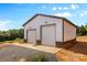 Exterior shot of a large metal garage with two bay doors and simple landscaping at 2710 Wyatt Grove Church Rd, Richfield, NC 28137