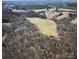 An aerial view of the property features a grassy lot ready for development amid a scenic wooded environment at 28926 Hartsell Rd, Albemarle, NC 28001