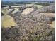 An aerial view shows the picturesque property amid a beautiful wooded and grassy rural landscape at 28926 Hartsell Rd, Albemarle, NC 28001