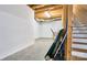 Unfinished basement with white brick wall, exposed ceiling, and stairs at 28926 Hartsell Rd, Albemarle, NC 28001