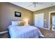 Cozy bedroom featuring neutral walls, white bedding, ceiling fan, and double door closet at 28926 Hartsell Rd, Albemarle, NC 28001