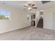 Well-lit bedroom with windows, stairs, wet bar, and neutral carpet at 2948 Christy Leigh Dr, Newton, NC 28658