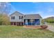Charming home with light gray and blue siding, black shutters, and a green lawn with mature trees under a blue sky at 2948 Christy Leigh Dr, Newton, NC 28658