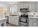 Close-up view of stainless steel appliances, gray cabinets, marble countertop, and fixtures in this well-lit kitchen space at 2948 Christy Leigh Dr, Newton, NC 28658