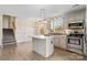 Bright eat-in kitchen with stainless steel appliances, light gray cabinets, a center island, and wood-look flooring at 2948 Christy Leigh Dr, Newton, NC 28658