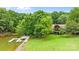 Lakefront home featuring a private dock, lush greenery, and well-maintained lawn at 307 Stillwater Rd, Troutman, NC 28166