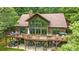 Back of home with a large wooden deck and a view of the green forest at 307 Stillwater Rd, Troutman, NC 28166