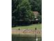 Waterfront house with an inviting deck overlooking the lake, surrounded by mature trees and well-maintained landscaping at 307 Stillwater Rd, Troutman, NC 28166