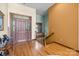 Front foyer showcasing hardwood floors, a wooden staircase, and a solid wood front door at 307 Stillwater Rd, Troutman, NC 28166