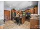 A cozy kitchen features wood cabinets, stainless steel appliances, tile backsplash, and a convenient center island with seating at 307 Stillwater Rd, Troutman, NC 28166