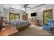 Bright main bedroom with a king bed, wood furniture, ceiling fan, and access to a private balcony at 307 Stillwater Rd, Troutman, NC 28166