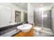 Well-lit bathroom features granite countertop, walk-in shower, and access to walk-in closet at 333 W Trade St # 1802, Charlotte, NC 28202