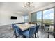 A modern dining room has a marble table, blue chairs, and an open layout with floor-to-ceiling windows at 333 W Trade St # 1802, Charlotte, NC 28202