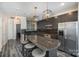 A modern kitchen boasts stainless steel appliances, dark grey cabinets, and an island with barstool seating at 333 W Trade St # 1802, Charlotte, NC 28202
