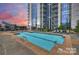 Tranquil rooftop pool at sunset with lounge chairs and city views at 333 W Trade St # 1802, Charlotte, NC 28202