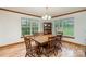 Traditional dining room with hardwood floors, a classic chandelier, and sun-filled windows overlooking the landscape at 3720 Lanes Creek Rd, Marshville, NC 28103