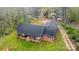 Aerial view of a red brick home with a covered front porch and black roof, surrounded by a green lawn at 3720 Lanes Creek Rd, Marshville, NC 28103