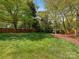 Large grassy backyard with privacy fence, shade trees, mature landscaping offering a private outdoor retreat at 3911 Kitley Pl, Charlotte, NC 28210