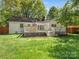 Spacious backyard features a large deck with stairs, a lush lawn and white brick on this well-maintained home at 3911 Kitley Pl, Charlotte, NC 28210