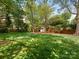 Expansive backyard with lush green grass, privacy fence, mature trees and an outbuilding to enjoy outdoor living at 3911 Kitley Pl, Charlotte, NC 28210