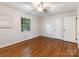Bright bedroom featuring hardwood floors, neutral paint, a large window, and a ceiling fan at 3911 Kitley Pl, Charlotte, NC 28210