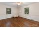 Spacious bedroom with hardwood floors, two large windows providing natural light, and a ceiling fan at 3911 Kitley Pl, Charlotte, NC 28210