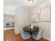 Cozy dining area featuring modern art, a brick accent wall, and hardwood floors, adjacent to the living room at 3911 Kitley Pl, Charlotte, NC 28210