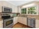 Bright kitchen featuring stainless steel appliances, granite countertops, and a window overlooking the backyard at 3911 Kitley Pl, Charlotte, NC 28210