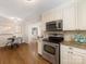 Well-lit kitchen adjacent to the dining area boasts stainless steel oven and microwave, plus granite countertops at 3911 Kitley Pl, Charlotte, NC 28210