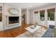 Inviting living room featuring a brick fireplace, access to an outdoor patio, and views into the kitchen at 3911 Kitley Pl, Charlotte, NC 28210
